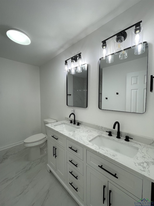 bathroom featuring marble finish floor, double vanity, a sink, and toilet