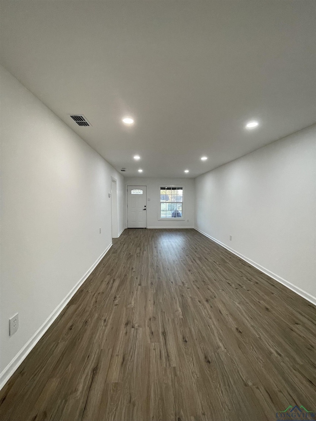 unfurnished living room featuring baseboards, visible vents, dark wood finished floors, and recessed lighting