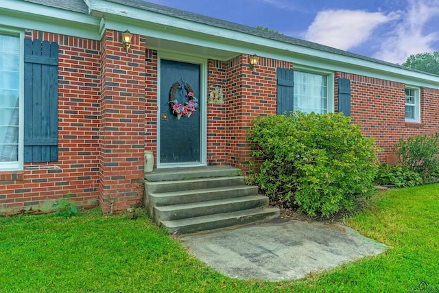 entrance to property with a lawn