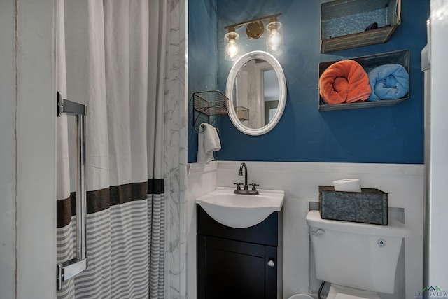 bathroom featuring a shower with shower curtain, vanity, and toilet