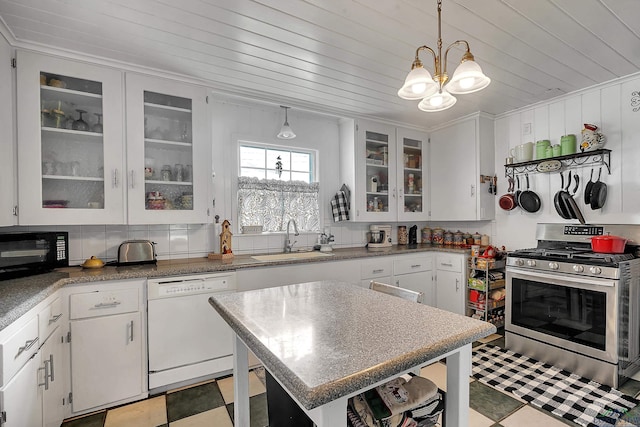 kitchen featuring white dishwasher, stainless steel range with gas cooktop, sink, decorative light fixtures, and white cabinetry