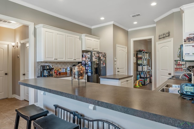 15579 County Road 1104, Flint, TX 75762 - kitchen featuring refrigerator with ice dispenser, dark countertops, decorative backsplash, recessed lighting, and white cabinetry