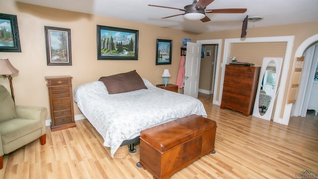 bedroom featuring a ceiling fan, baseboards, and light wood-style floors