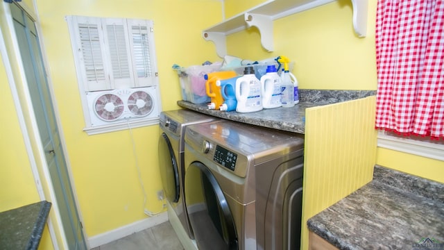 laundry area with baseboards, light tile patterned floors, washer and clothes dryer, and laundry area