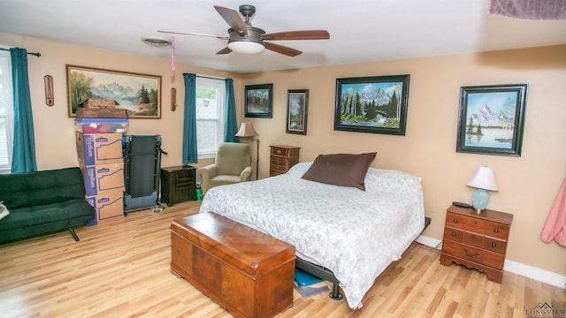 bedroom with visible vents, light wood-type flooring, and a ceiling fan