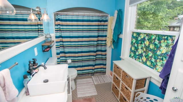 bathroom featuring toilet, a sink, and a shower with shower curtain