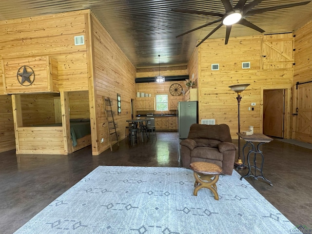 226 Almand, Waskom, TX 75692 - living room featuring wooden walls, ceiling fan, and finished concrete floors