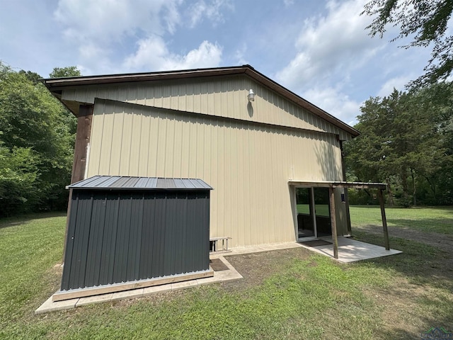 226 Almand, Waskom, TX 75692 - view of side of home featuring a lawn, a standing seam roof, metal roof, and a patio