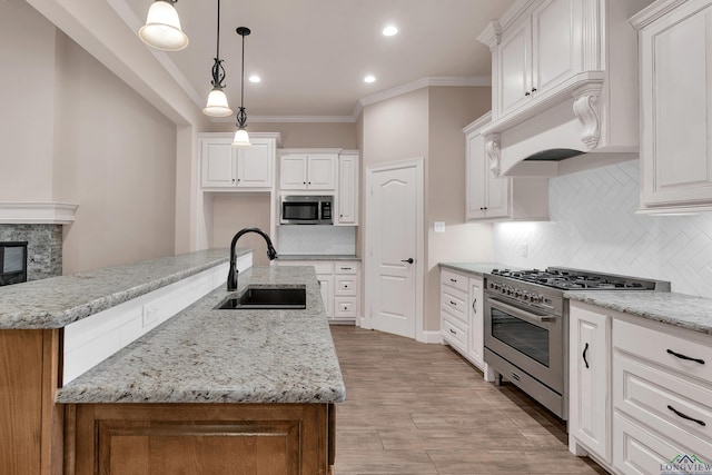 kitchen with white cabinets, appliances with stainless steel finishes, and a center island with sink