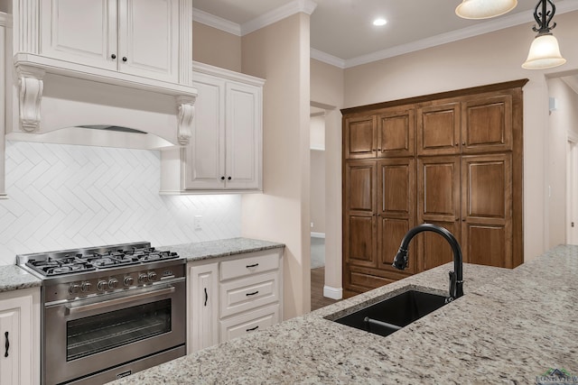 kitchen featuring white cabinets, backsplash, stainless steel stove, and sink