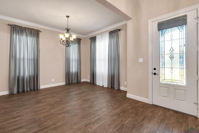 foyer featuring dark hardwood / wood-style floors, crown molding, and a chandelier