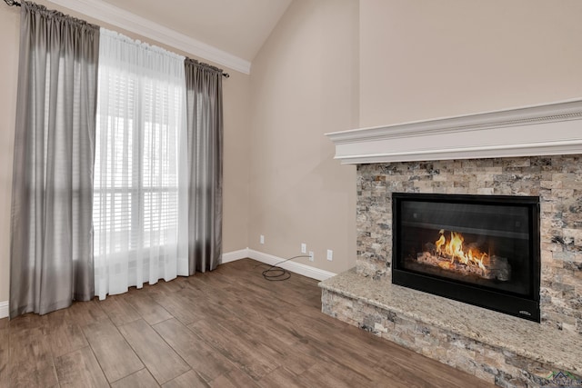 unfurnished living room with hardwood / wood-style floors, vaulted ceiling, and a stone fireplace