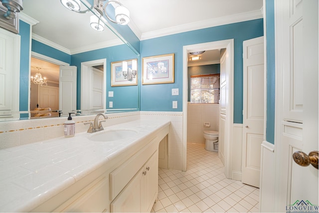 bathroom featuring a notable chandelier, tile patterned floors, toilet, vanity, and ornamental molding