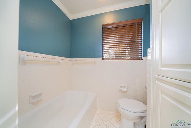 bathroom with tile patterned floors, crown molding, toilet, a tub to relax in, and tile walls