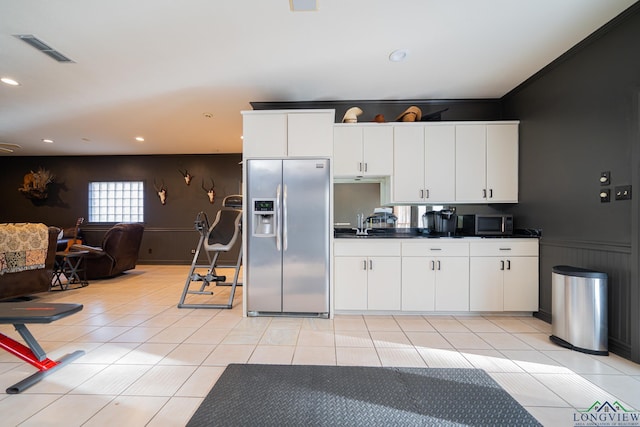 kitchen featuring appliances with stainless steel finishes, sink, white cabinetry, and light tile patterned flooring