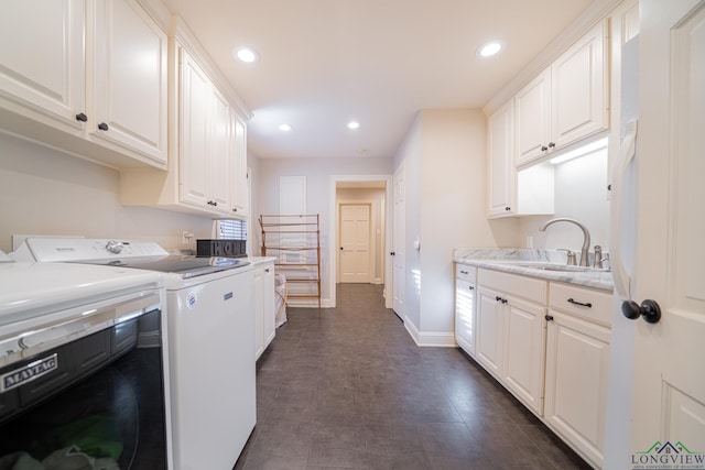 washroom with separate washer and dryer, sink, and cabinets