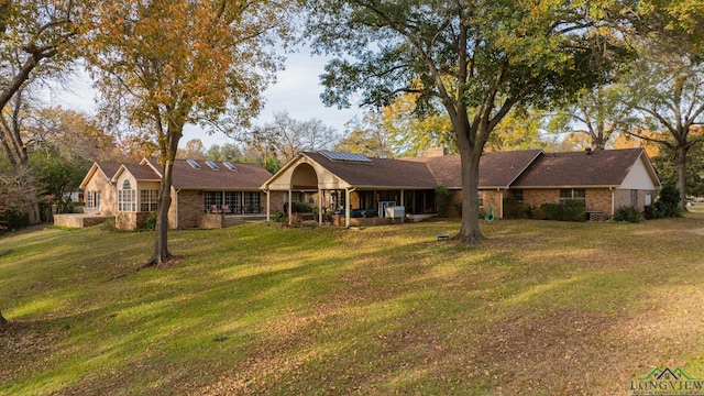 ranch-style home featuring solar panels and a front yard