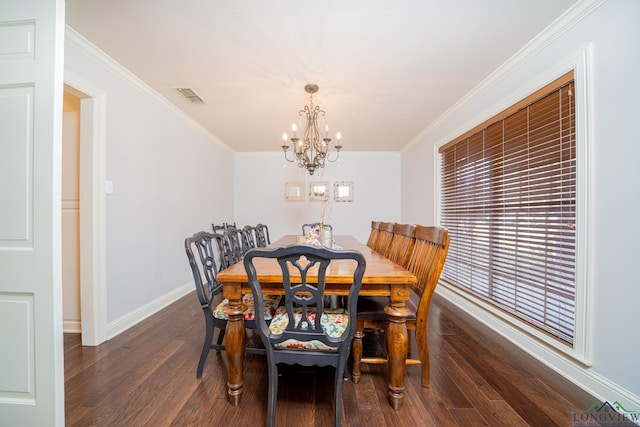 dining area featuring dark hardwood / wood-style floors, crown molding, and an inviting chandelier