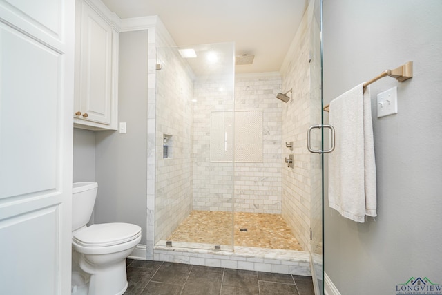 bathroom featuring tile patterned floors, toilet, and a shower with door