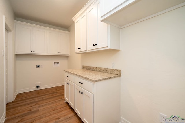 laundry room featuring electric dryer hookup, cabinets, hardwood / wood-style flooring, and hookup for a washing machine