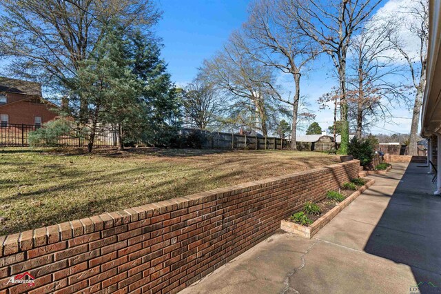 327 Forest Hls, Hallsville, TX 75650 - fenced backyard with a patio area