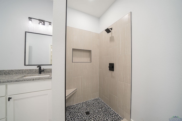 bathroom with vanity and a tile shower