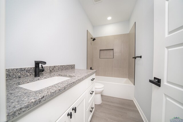 full bathroom featuring shower / bathing tub combination, wood-type flooring, vanity, and toilet