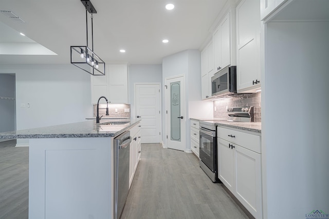 kitchen with sink, white cabinets, a center island with sink, and appliances with stainless steel finishes