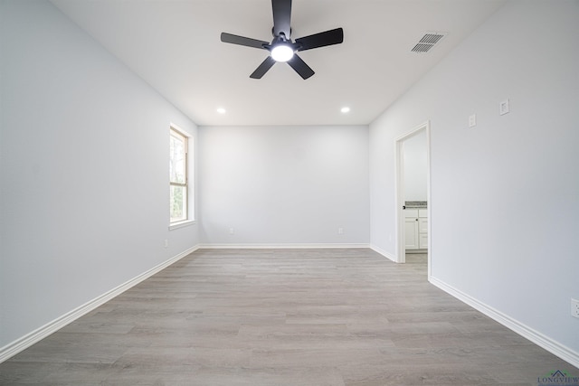 spare room featuring light hardwood / wood-style flooring and ceiling fan