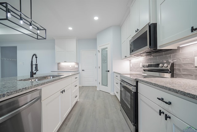 kitchen featuring white cabinets, appliances with stainless steel finishes, and sink