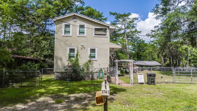 exterior space with a gate, a fenced backyard, and a lawn
