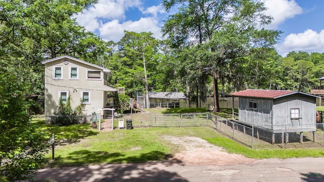 view of yard featuring an outdoor structure, stairs, and fence