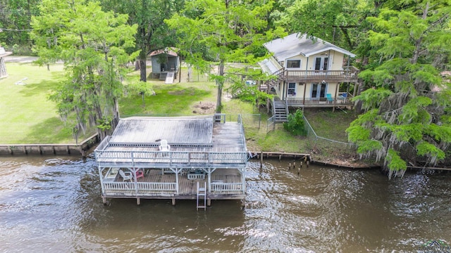 dock area with fence, stairway, a deck with water view, and a yard