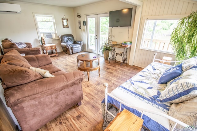 living area featuring wood finished floors, plenty of natural light, ornamental molding, and a wall mounted AC