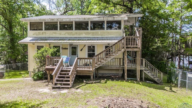 view of front facade with a front lawn, stairway, and fence