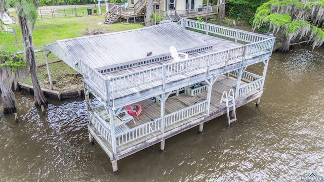 dock area with a yard, stairway, a deck with water view, and fence