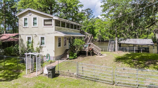 view of front of home with a front lawn, stairway, and a fenced backyard