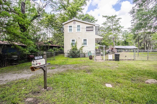 view of front of home with a front yard, a gate, and fence