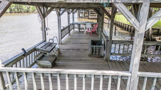 wooden deck with boat lift, a boat dock, and a water view