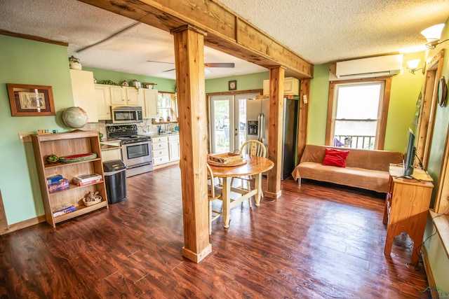 kitchen featuring a wealth of natural light, appliances with stainless steel finishes, a wall unit AC, a textured ceiling, and dark wood-type flooring