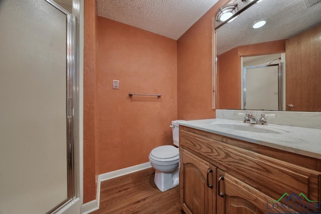 324 Highlander Hts, Hideaway, TX 75771 - bathroom with a shower stall, wood finished floors, vanity, toilet, and a textured ceiling
