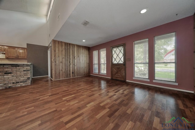 324 Highlander Hts, Hideaway, TX 75771 - unfurnished living room featuring dark wood finished floors, baseboards, and wood walls