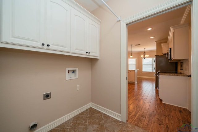 clothes washing area with a chandelier, dark hardwood / wood-style flooring, cabinets, washer hookup, and electric dryer hookup