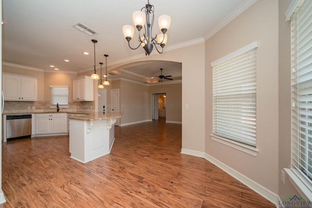 kitchen with crown molding, dishwasher, white cabinetry, hanging light fixtures, and light stone countertops