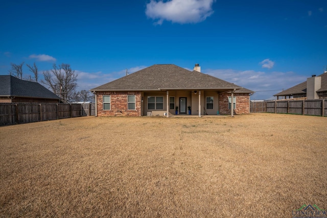 rear view of house featuring a yard