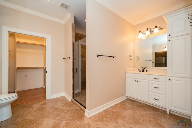 bathroom with vanity, crown molding, toilet, and walk in shower