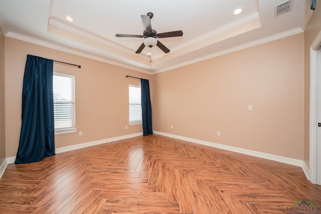 unfurnished room with ceiling fan, ornamental molding, light parquet flooring, and a raised ceiling