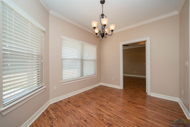 unfurnished room with ornamental molding, wood-type flooring, and a notable chandelier