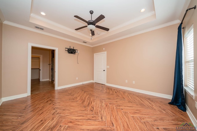 empty room with parquet flooring, ornamental molding, a raised ceiling, and ceiling fan