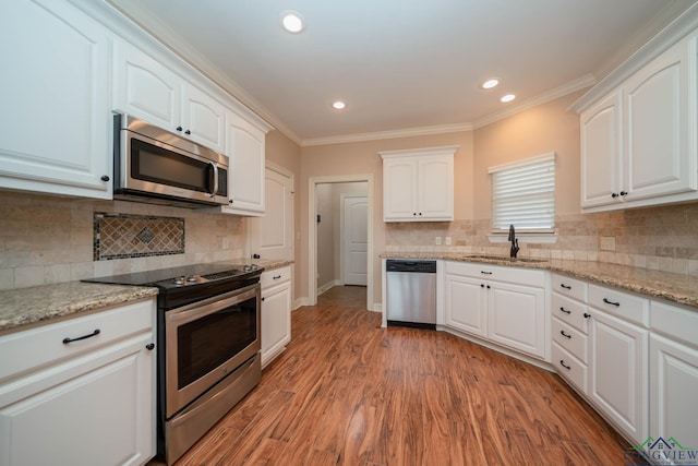 kitchen featuring white cabinetry, sink, stainless steel appliances, crown molding, and light hardwood / wood-style flooring